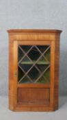 A 19th Century mahogany corner display cabinet, with an astragal glazed door, the green interior