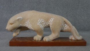 A large Art Deco glazed spotted ceramic panther sculpture, signed E. Pierre for Atelier Primavera.