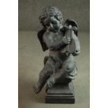 A clay statue of a Cherub playing a lyre on a pedestal base. H.73cm.