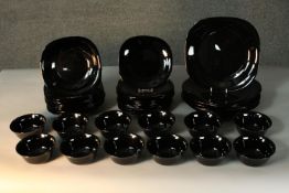 A twelve person black glass dinner service. Marked ARC, France to the base.