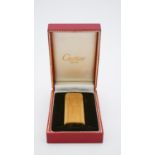 A Cartier gold plated ridged design lighter, signed Cartier, Paris, plaque d'or, in original