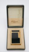 A boxed vintage gold plated and black enamel Du Pont of Paris cigarette lighter with red Japanese