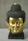 A 20th century gilded carved wooden Buddha head on a pedestal base. H.55 W.30cm.