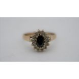 A black stone and cubic zirconia vintage cluster ring. Set to centre with an oval mixed cut black