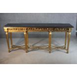 A long giltwood console table, with a rectangular black marble top, on fluted legs, joined by X