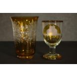 Two early 20th century Bohemian glass pieces. An amber painted clear glass etched rummer with a