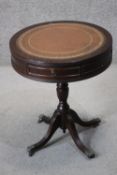 A George III style mahogany drum table, with a tooled brown leather skiver and two drawers, on a