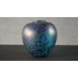 An art glass vase with oil slick finish and blue and green marbled design. H.18 W.17cm
