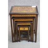 An Indonesian hardwood quartetto nest of four tables, each set with a carved figural panel.