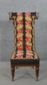 A Victorian walnut prie dieu chair, upholstered with embroidery, depicting two columns of foliage