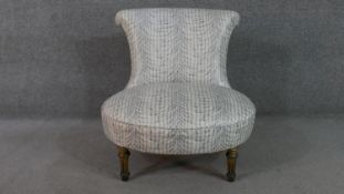 A Victorian nursing chair, on turned and fluted ebonised and gilded legs.