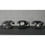 Two vintage black GPO bakelite telephones and another German phone, one with slide out tray and each