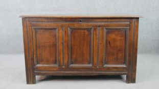 An 18th century oak coffer, of panelled construction with a plank top. H.71 W.121 D.54cm