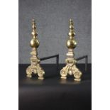 A pair of Victorian brass and cast iron fire dogs with floral motifs and turned finials. H.44 W.
