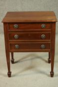 A George III style mahogany bedside chest of three long drawers, flanked by fluted detail, on square