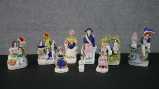 A collection of nine 19th century Staffordshire pottery figures, including two figural spill vases