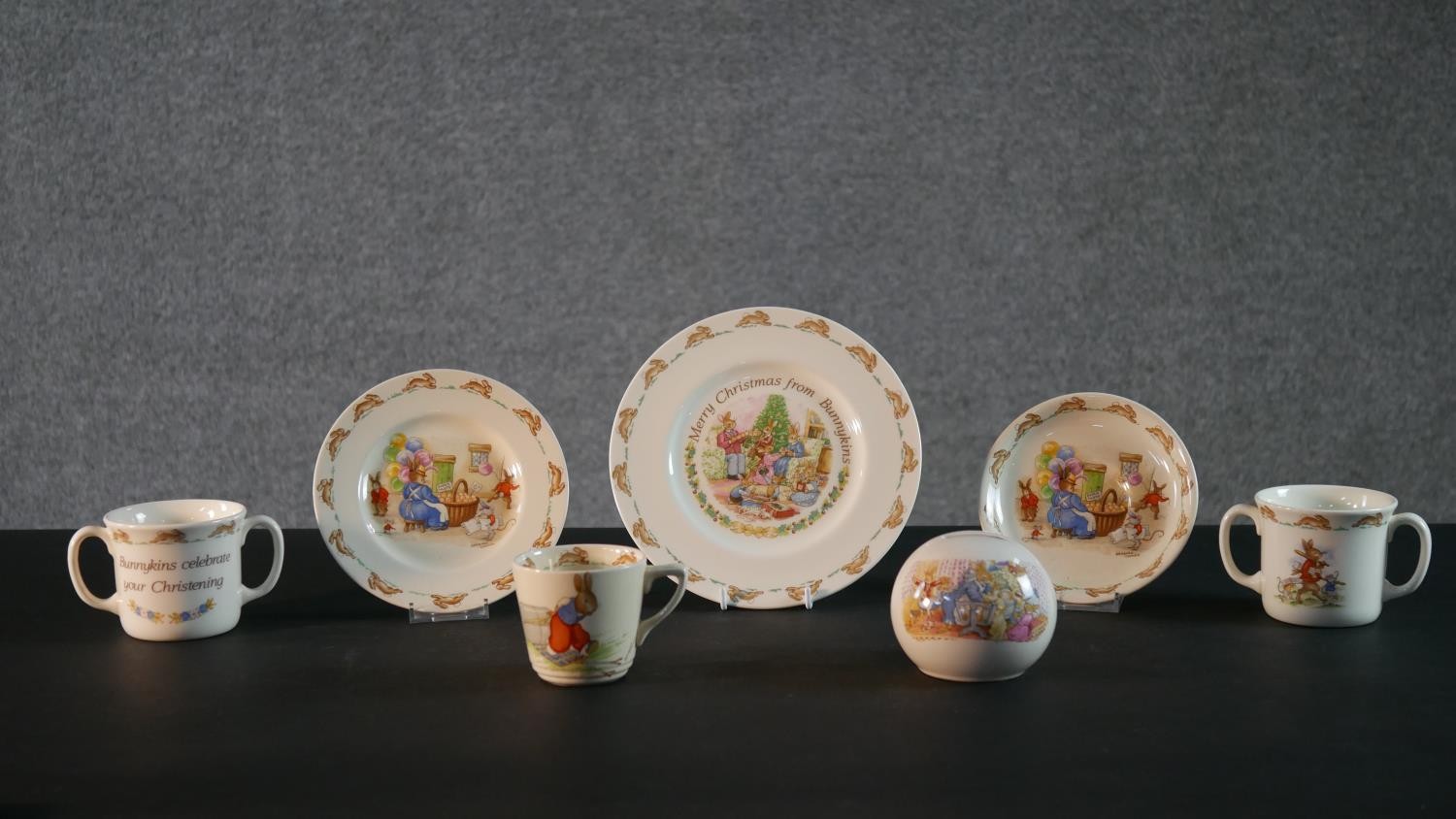 A collection of Royal Doulton Bunnykins pattern child's crockery, includes three cups, a moneybox, a