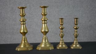 Two pairs of early 20th century brass candle sticks, one set with octagonal bases. H.27.5 W.11.5 D.
