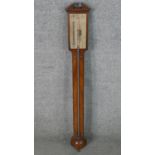 A George III mahogany stick barometer, with a broken arch, the silvered gauge inscribed Ware