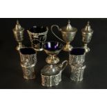 A collection of silver plate, including a pierced design cruet set with blue glass liners and a salt