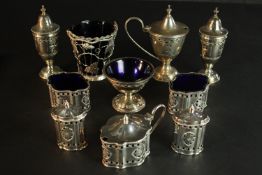 A collection of silver plate, including a pierced design cruet set with blue glass liners and a salt