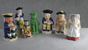 A collection of seven hand painted early 20th century ceramic Toby jugs of various designs. H.28 W.