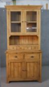 A 20th century pine dresser, with a pair of glazed doors, over four short drawers, two short drawers