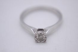 A 9 carat white gold illusion set diamond solitaire ring. Set with a round brilliant cut diamond