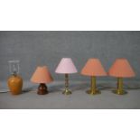 A collection of five table lamps, including a brass pair, with salmon coloured shades, on