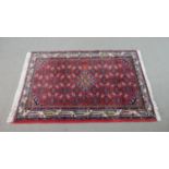 A red ground Persian handmade Hamadan rug. L.145 W.112cm