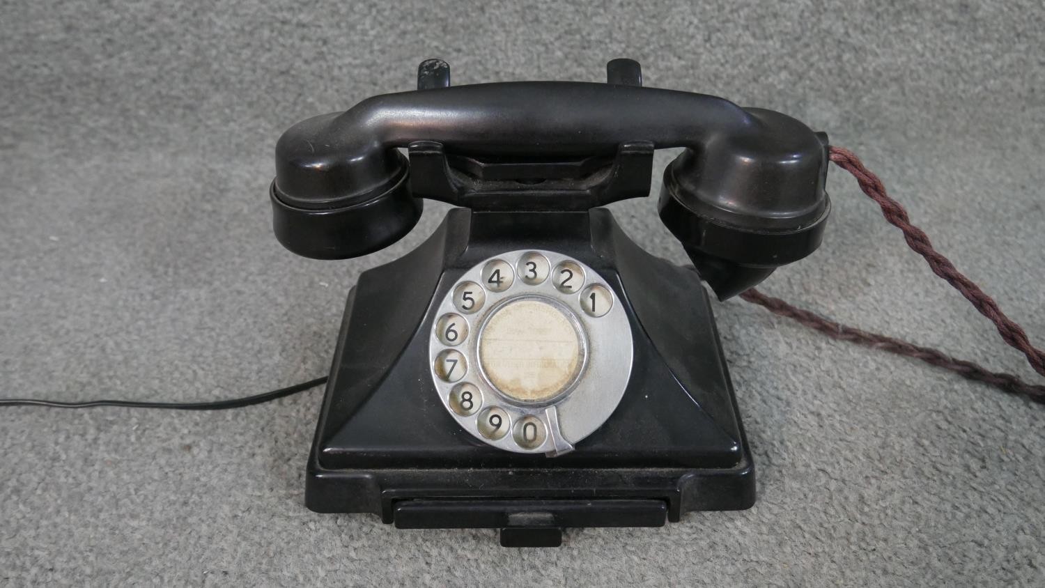 A vintage black Bakelite telephone with pull out note tray. H.16 W.18 D.14cm