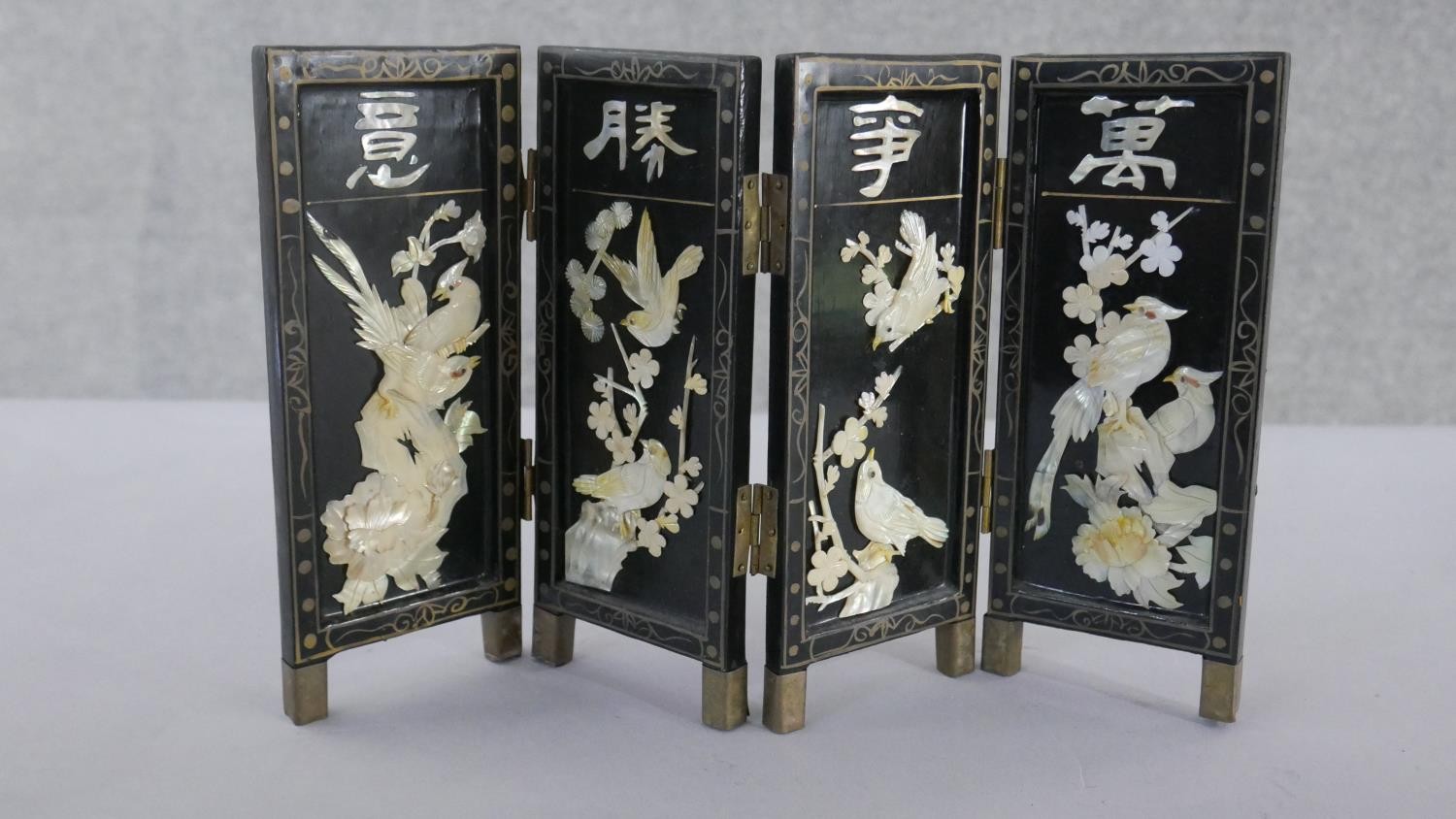 A miniature Japanese mother of pearl and lacquer folding screen. Decorated with birds, cherry