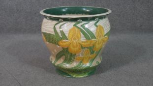 A Minton Secessionist jardinière decorated with yellow flag irises on a water ripple background.