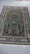 A green ground fine handmade part silk Persian Kum rug. L.207 W.136cm