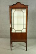 A circa 1900 mahogany display cabinet, the arched top over a glazed door and sides, enclosing