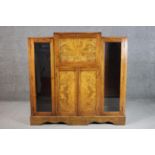 An Art Deco figured walnut bureau cabinet with a fall front enclosing a fitted interior, over a pair