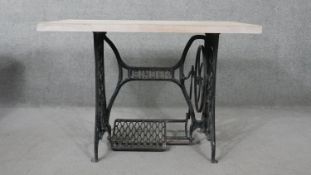 A contemporary table with limed oak top on wrought iron Singer sewing machine base C.1900. H.76 W.
