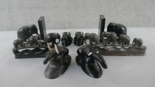A collection of 20th century carved ebony elephants, including a pair of bookends, three elephants