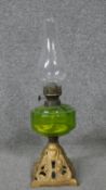 A gold painted brass Art Nouveau style oil lamp with green glass reservoir and glass funnel. H.41