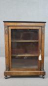 A Victorian walnut and inlaid pier cabinet, with a glazed door, enclosing shelves, with gilt metal