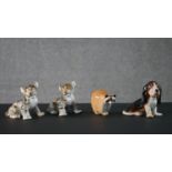 A collection of Lomonosov porcelain animals, including two tiger cubs, a racoon and a Basset Hound