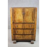 An Art Deco figured walnut tallboy cabinet, with two cupboard doors over three long drawers. H.120