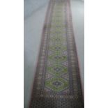 A green ground Bokhara motif runner. L.350 W.70cm