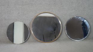 Three circular wall mirrors, one with a frameless bevelled edge, another similar, the third with a