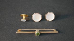 A 9ct gold bar brooch set with a oval mixed cut peridot with an approximate carat weight of 0.