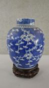 A large 19th century blue and white prunus blossom design lidded ginger jar on carved and pierced