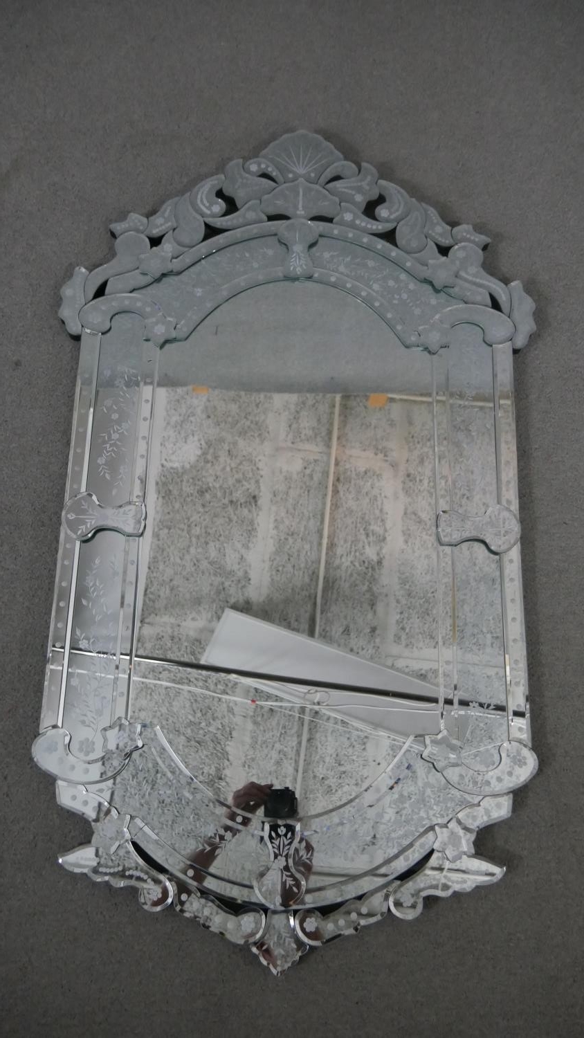 A Venetian style wall mirror, the ornate mirrored frame with bevelled edges and etched foliate