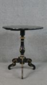A black painted and parcel gilt tripod table, the top painted with flowers, on a turned stem, with