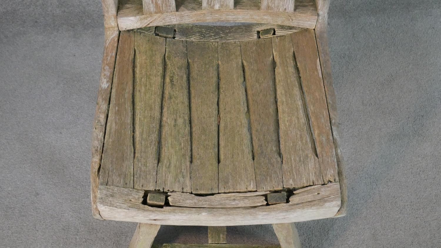 A rustic wooden garden chair, the three splat back over a curved slatted seat, the legs joined by an - Image 2 of 5