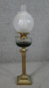A Victorian brass Corinthian column design oil lamp with faceted glass oil well and etched frosted